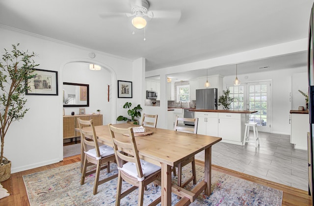 1032 Windward Rd, Charleston, SC 29412 - dining space with a ceiling fan, arched walkways, light wood finished floors, and ornamental molding