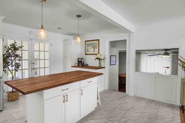 1032 Windward Rd, Charleston, SC 29412 - kitchen with butcher block countertops, light marble finish flooring, and white cabinetry