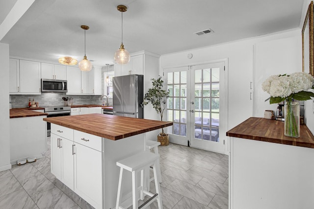 1032 Windward Rd, Charleston, SC 29412 - kitchen with butcher block countertops, stainless steel appliances, french doors, and healthy amount of natural light