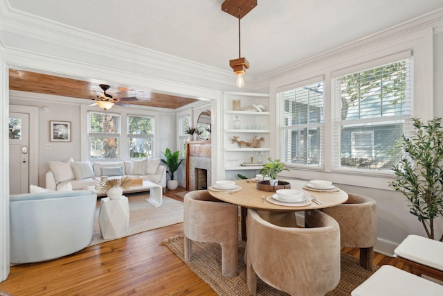 dining room featuring ceiling fan, hardwood / wood-style floors, built in features, and ornamental molding