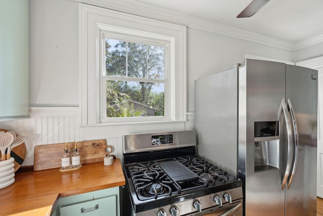 kitchen featuring wood counters, stainless steel appliances, and ornamental molding