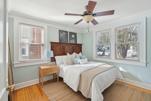 bedroom with hardwood / wood-style flooring, ceiling fan, and crown molding