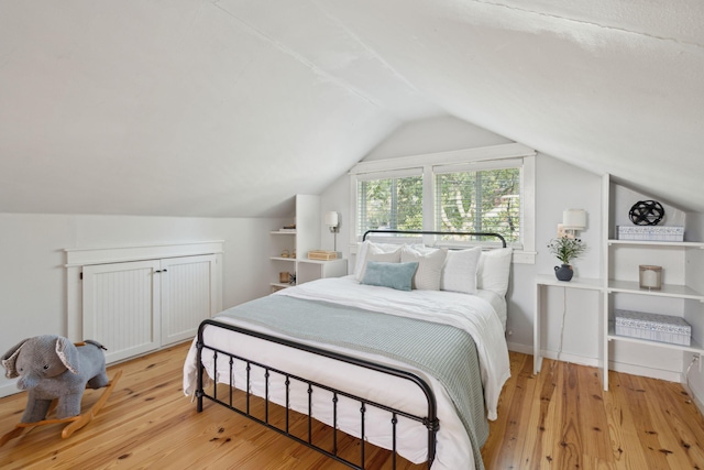 bedroom featuring light hardwood / wood-style flooring and lofted ceiling