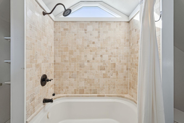 bathroom with shower / bath combo and lofted ceiling