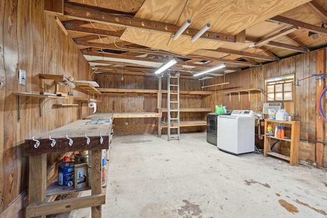 basement featuring washing machine and dryer and wooden walls