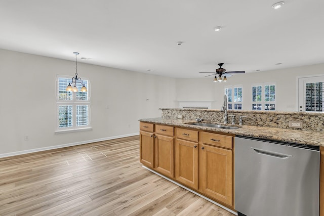 kitchen featuring stainless steel dishwasher, plenty of natural light, a sink, and light wood-style flooring