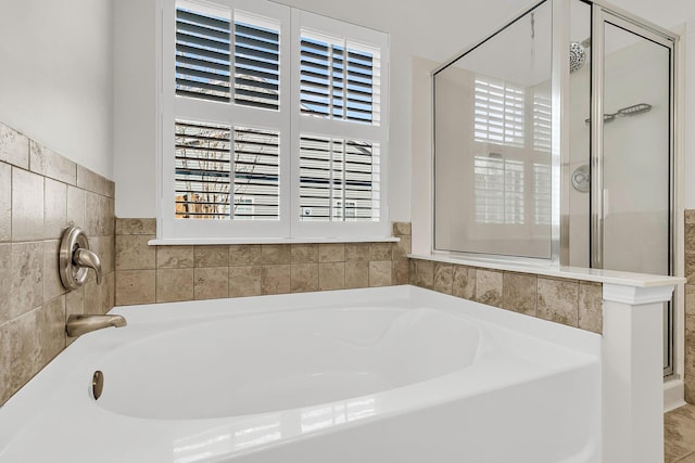 full bath featuring a stall shower and a garden tub