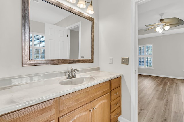 bathroom featuring a ceiling fan, a wealth of natural light, vanity, and wood finished floors