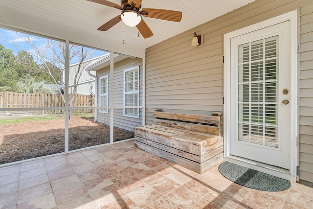 unfurnished sunroom with ceiling fan