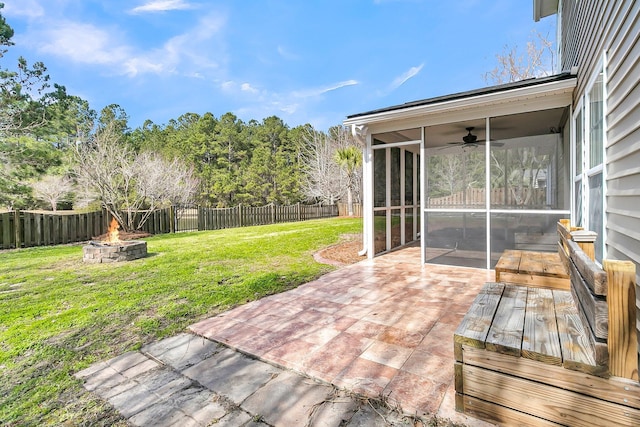 view of patio / terrace with an outdoor fire pit, a fenced backyard, and a sunroom