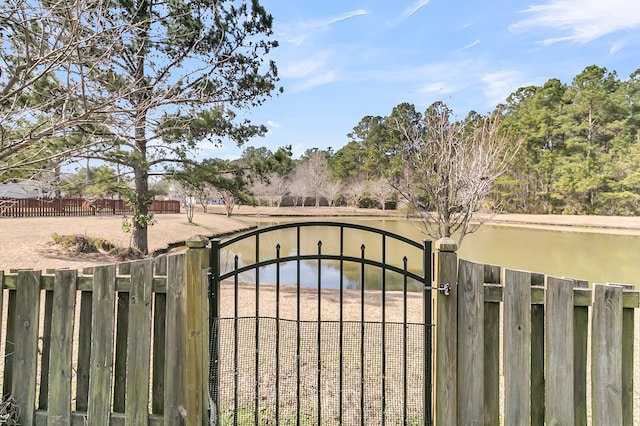 view of gate featuring a water view and fence