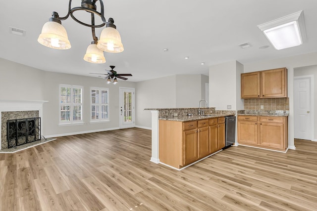 kitchen featuring a sink, visible vents, a high end fireplace, open floor plan, and decorative backsplash