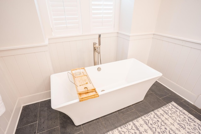 1566 Lindsey Creek Dr, Mount Pleasant, SC 29466 - bathroom featuring a wainscoted wall, a freestanding bath, a decorative wall, and tile patterned flooring