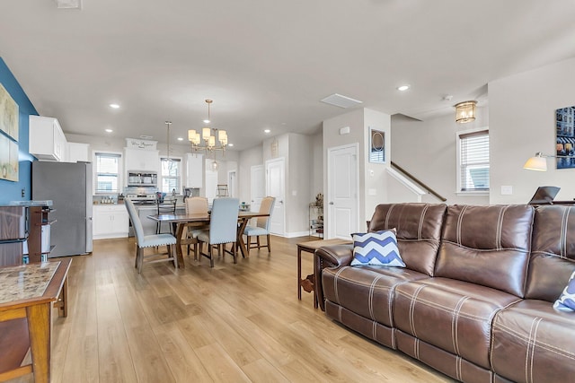 living room featuring light hardwood / wood-style floors and an inviting chandelier