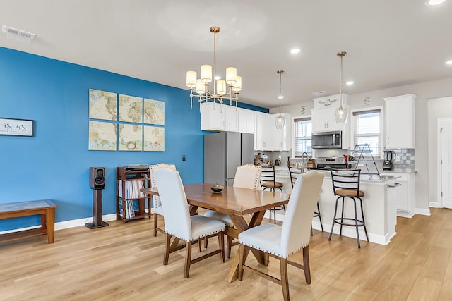 dining area featuring an inviting chandelier and light wood-type flooring