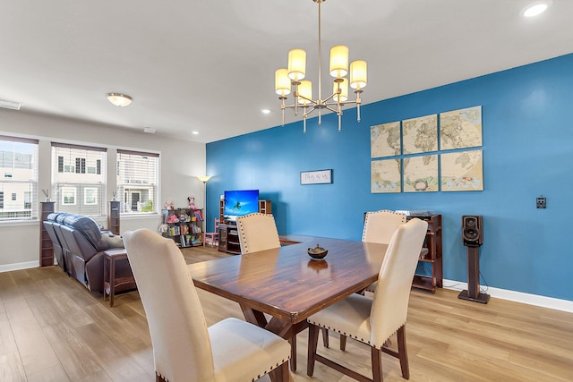 dining area with a chandelier and light wood-type flooring