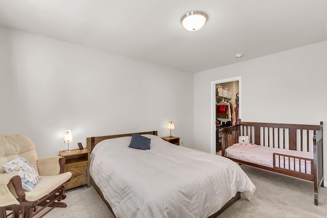 carpeted bedroom featuring a walk in closet and a closet