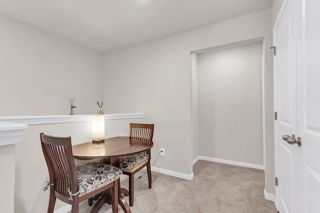 dining space featuring light carpet