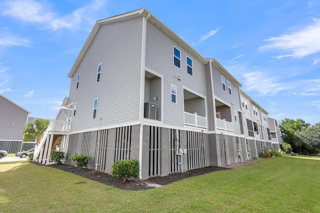 view of side of home with a yard, a balcony, and cooling unit