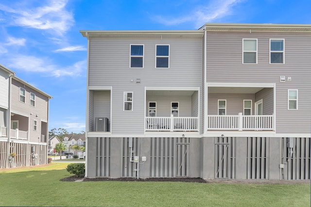 rear view of property with a yard and a balcony