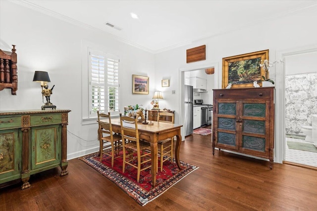 dining room with ornamental molding, visible vents, baseboards, and dark wood-style floors