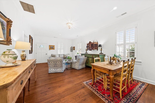 dining area with dark wood-style floors, baseboards, visible vents, and crown molding