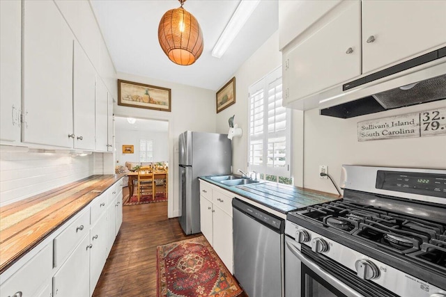 kitchen featuring dark wood-style flooring, appliances with stainless steel finishes, white cabinetry, a sink, and under cabinet range hood