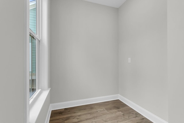 spare room with dark wood-style floors and baseboards