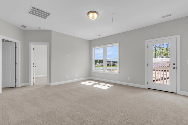 empty room with light colored carpet, plenty of natural light, and baseboards