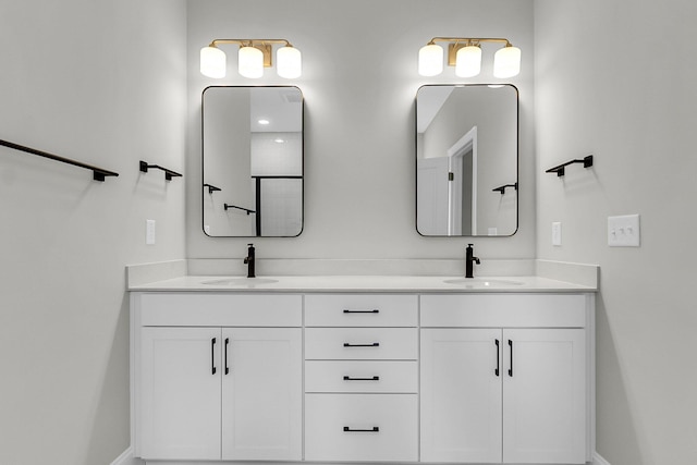 full bath featuring double vanity and baseboards