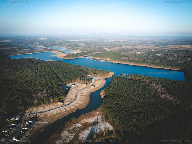 aerial view with a water view and a forest view