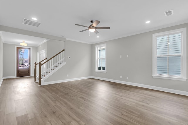 unfurnished room with stairs, ornamental molding, a ceiling fan, baseboards, and wood finished floors