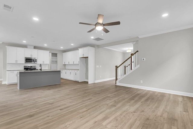unfurnished living room featuring ceiling fan, baseboards, light wood finished floors, ornamental molding, and recessed lighting