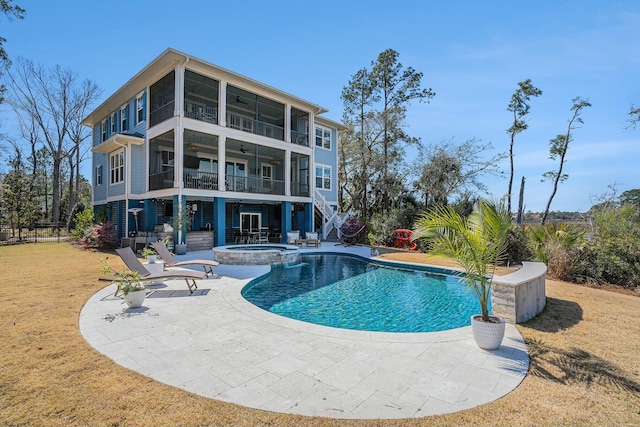 view of pool with a patio, a ceiling fan, a yard, a pool with connected hot tub, and stairs