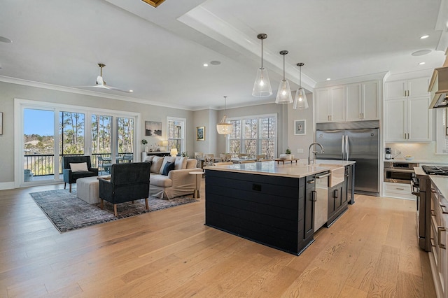 kitchen with open floor plan, light countertops, light wood-type flooring, white cabinetry, and high end appliances