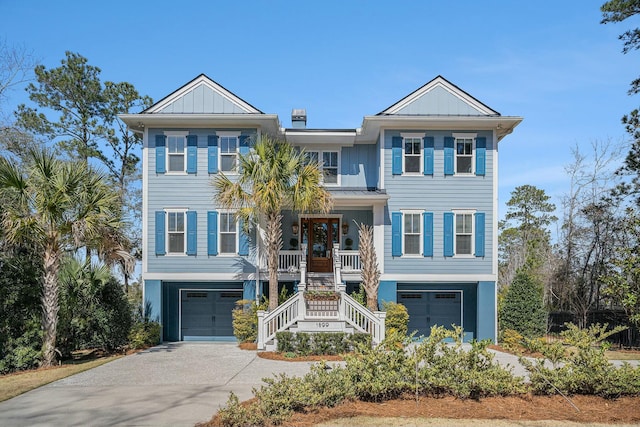 coastal inspired home with an attached garage, concrete driveway, stairs, and board and batten siding