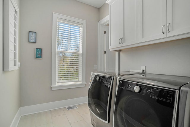 washroom featuring a wealth of natural light, visible vents, cabinet space, and independent washer and dryer