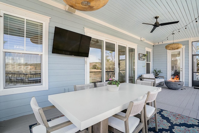 exterior space with a deck, outdoor dining area, and a ceiling fan