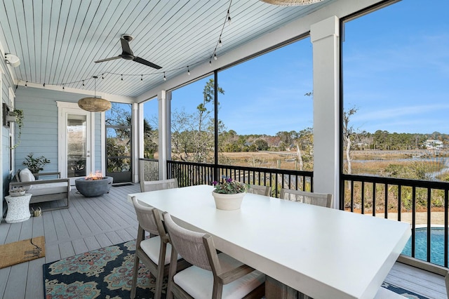 sunroom / solarium featuring a ceiling fan