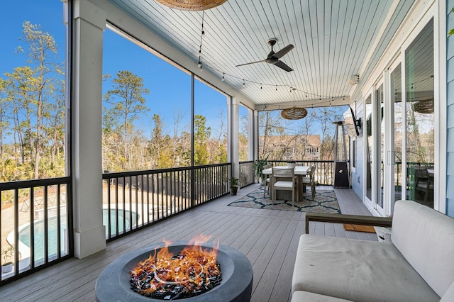 sunroom / solarium featuring plenty of natural light and a ceiling fan