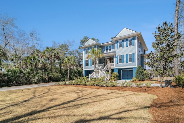 coastal home with stairway, a garage, board and batten siding, and a front yard