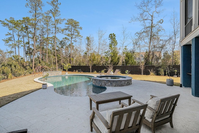 view of pool with a pool with connected hot tub, a fenced backyard, and a patio area