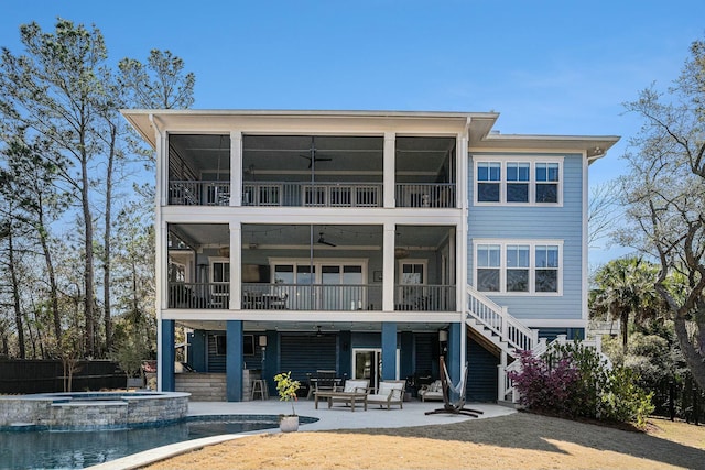 rear view of property with a patio, stairway, and a sunroom