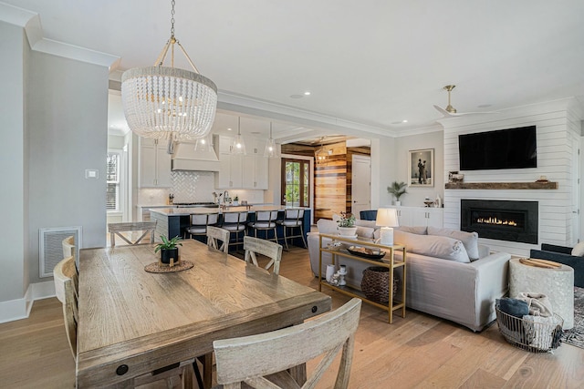 dining room featuring visible vents, light wood-style flooring, and ornamental molding