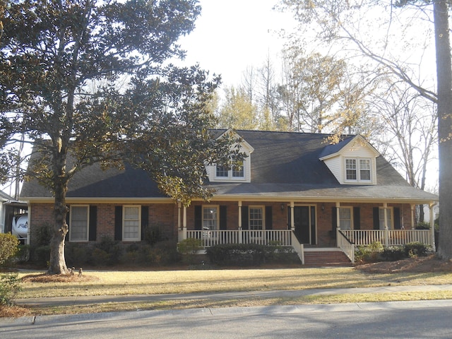 new england style home with brick siding and a porch