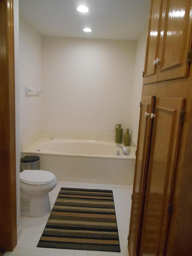 bathroom featuring tile patterned flooring, toilet, a bath, and recessed lighting