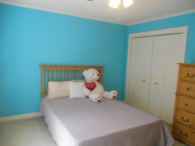 bedroom with a closet, baseboards, carpet floors, and crown molding