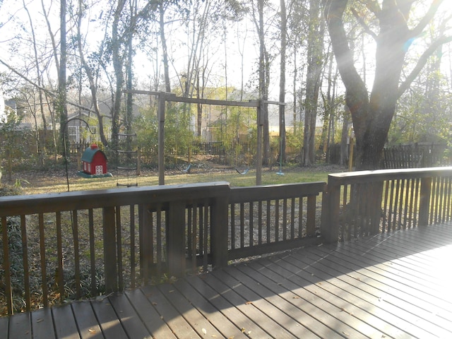 wooden terrace featuring a playground, a yard, and fence