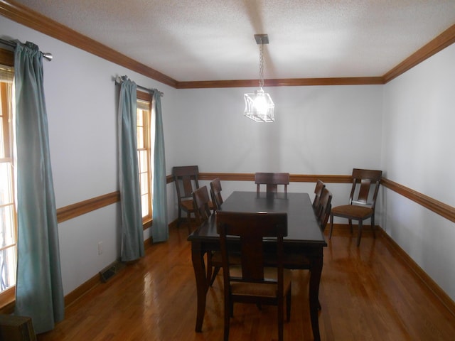 dining room featuring visible vents, a chandelier, wood finished floors, and ornamental molding