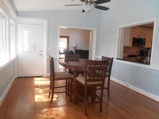 dining room with baseboards, lofted ceiling, ceiling fan, and light wood finished floors